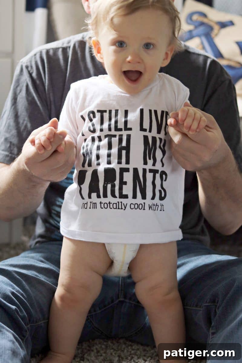 8 Heartwarming Ways to Celebrate a New Dad's First Father's Day 4 Cute baby wearing 'I still live with my parents' onesie