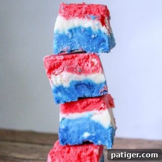 A red, white, and blue marshmallow creme fudge recipe made with marshmallow creme, evaporated milk, white chocolate chips, sugar, butter, and food coloring.