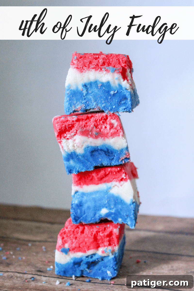 A large block of red, white, and blue marshmallow creme fudge, showing off its beautiful layers, cut into perfect squares for serving.
