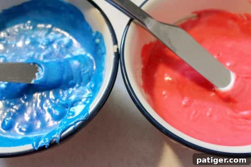 The marshmallow creme fudge mixture divided into three bowls, with one part being dyed blue, one red, and one remaining white for a patriotic layered fudge.
