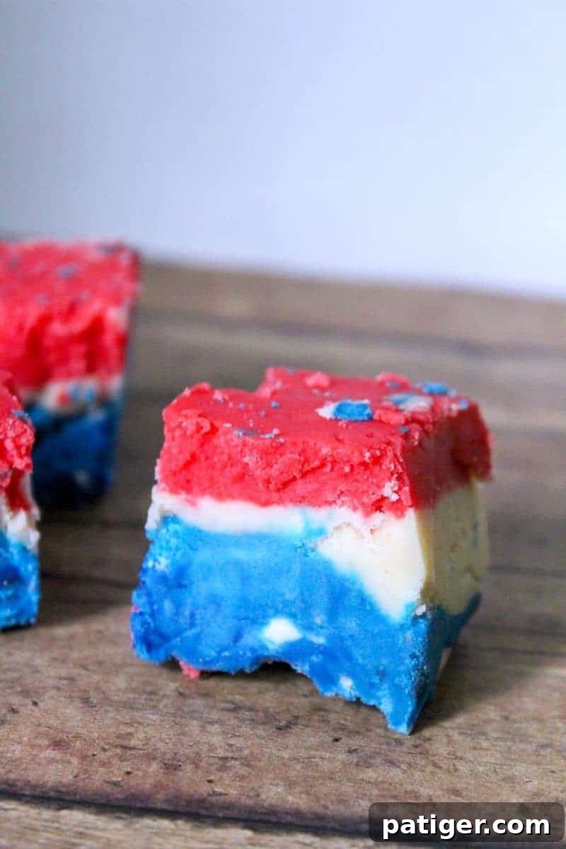 The final set Red, White, and Blue Fudge, ready to be sliced and served for a festive occasion. This marshmallow creme fudge is creamy and colorful.