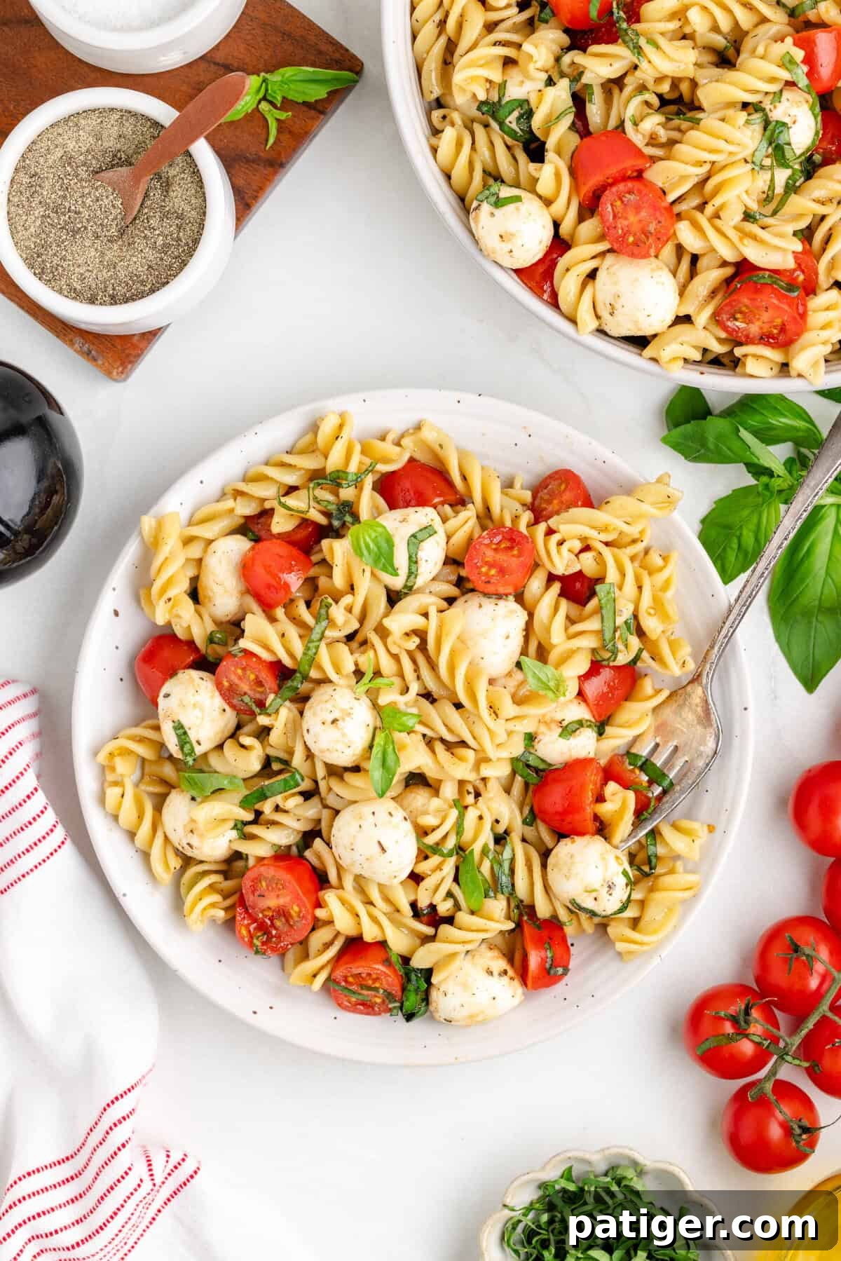 Sun-Kissed Caprese Pasta Salad 6 Bowl of rotini pasta salad with cherry tomatoes, mozzarella balls, and basil.