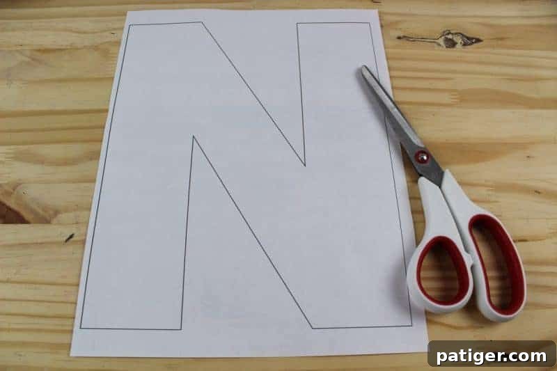 Nifty Nests Printable Letter N Craft 4 Step 1 in creating the Letter N is for Nest craft: Carefully cutting out the large letter N shape from the printable template, preparing for the next stage of crafting.