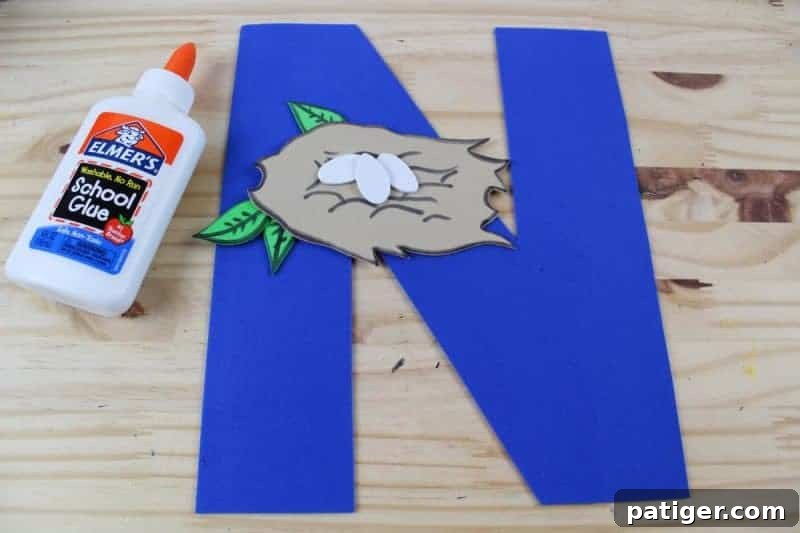 Nifty Nests Printable Letter N Craft 9 Step 7 in the Letter N craft: Carefully gluing the assembled nest onto the crafted letter N, completing the main structure of the 'N is for Nest' project.