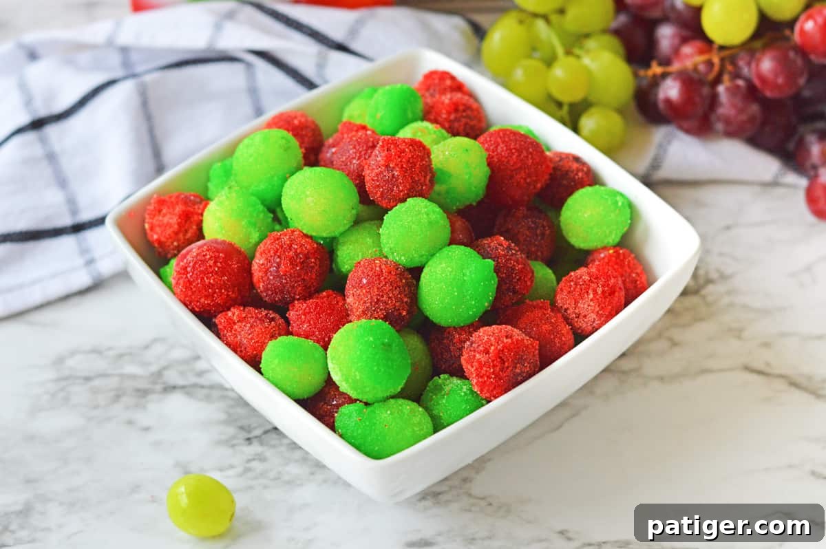 Candied grapes made with red and green jello powder in a white bowl.