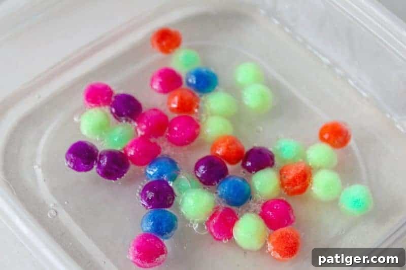 Mixing clear glue, water, and pom poms in a second bowl.