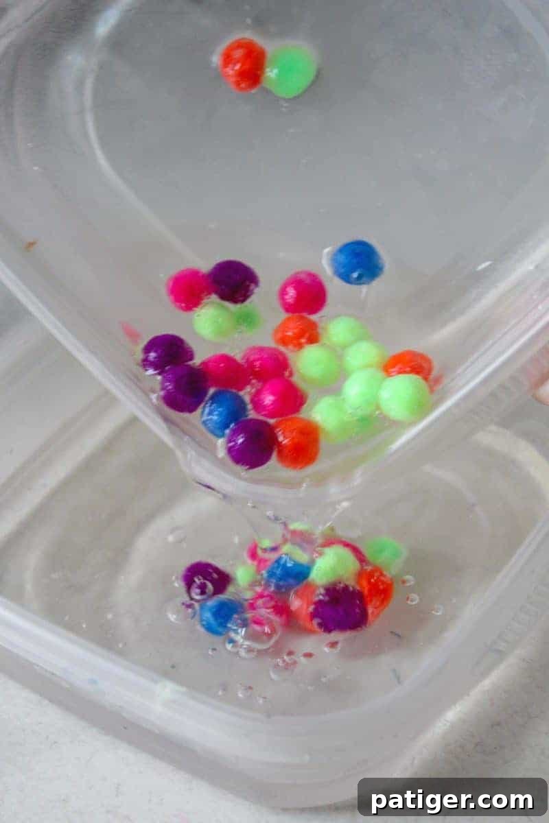 Pouring the glue and pom pom mixture into the borax solution.