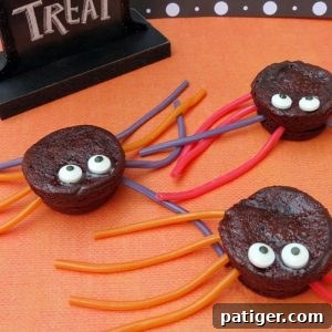 Spider brownie treats made with brownie bites, candy eyeballs, and licorice ropes, ready for a Halloween party.