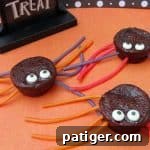 Spider brownie treats made with brownie bites, candy eyeballs, and licorice ropes, a close-up.