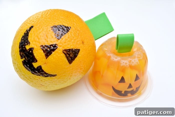 Jack-o-lantern faces drawn on an orange and a peach fruit cup for Halloween snacks