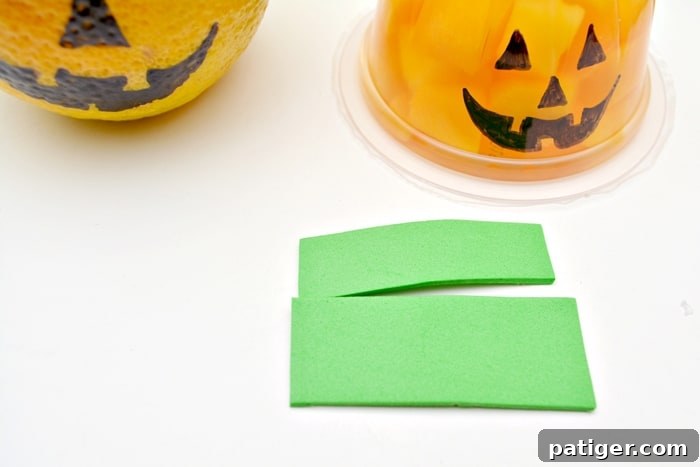 Step-by-step image showing how to draw a jack-o-lantern face and add a foam stem to a fruit cup or clementine