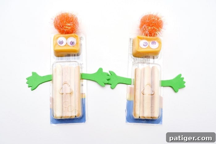Packaged cheese and cracker stick decorated as a green monster with googly eyes and foam arms