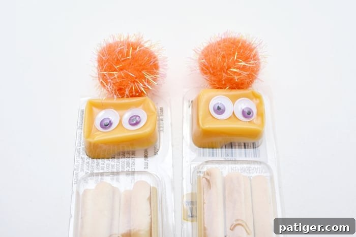 Step-by-step image showing how to glue a pom-pom and googly eyes onto a cheese and cracker package for a monster snack
