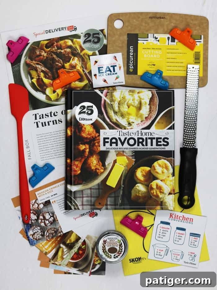 A vibrant display of the contents from the Taste of Home Special Delivery Fall 2018 Subscription Box. The image highlights a hardcover cookbook, various kitchen gadgets like a skinny spatula and microplane zester, and a prominent jar of Gustus Vitae spicy chocolate cinnamon cane sugar, all promising a wealth of culinary adventures for the home cook.