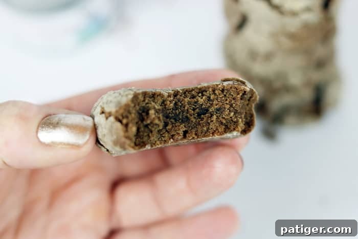 A stack of freshly baked Mexican Crinkle Cookies with a Kick, featuring the distinct crinkled tops and a generous dusting of powdered sugar. The cookies, imbued with Gustus Vitae Spicy Chocolate Cinnamon Cane Sugar, are presented on a white plate, emphasizing their delicious appeal as a sweet and savory treat.
