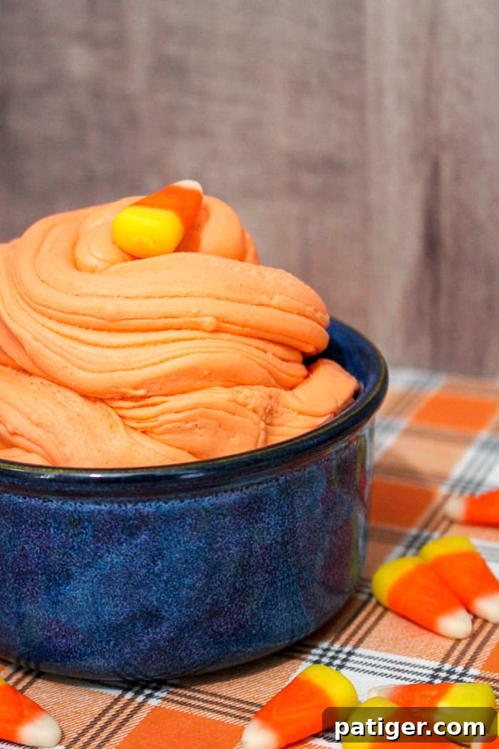 Vibrant orange, yellow, and white taste-safe candy corn slime in a bowl, perfect for Halloween sensory play