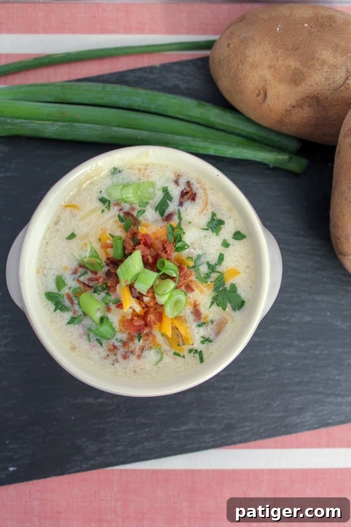 A steaming bowl of creamy Instant Pot potato soup, garnished with fresh chives and crispy bacon, promising a warm and hearty meal.