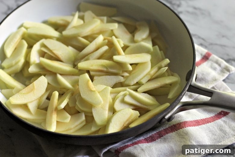 The process of preparing the apple filling for danishes, showing apples cooking in a frying pan with butter, brown sugar, cornstarch, and cinnamon.