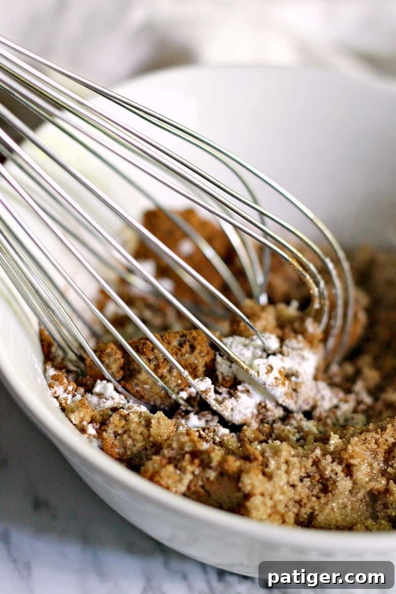 A close-up image showing ingredients being whisked together in a bowl, preparing for the apple danish filling.