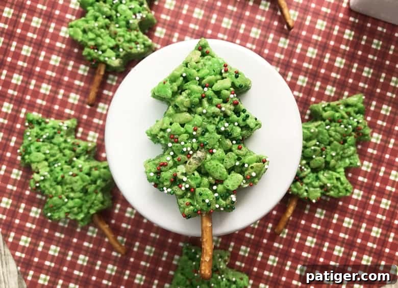 Vibrant green Christmas Tree Rice Krispie Treats decorated with festive sprinkles, perfect for a holiday dessert table.