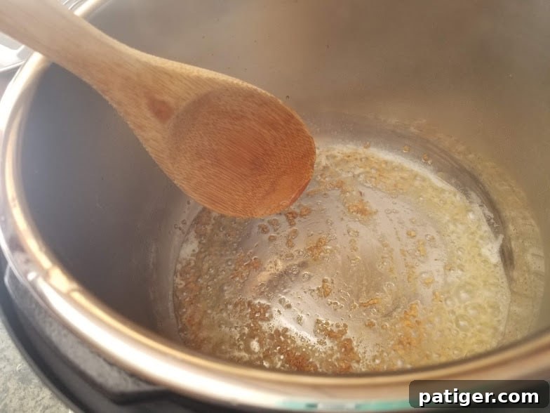 Browned garlic sizzling in olive oil inside the Instant Pot.