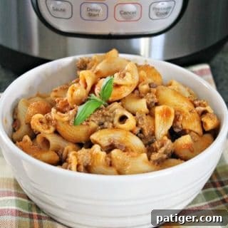 Cheesy Hamburger Casserole in a white bowl in front of an Instant Pot