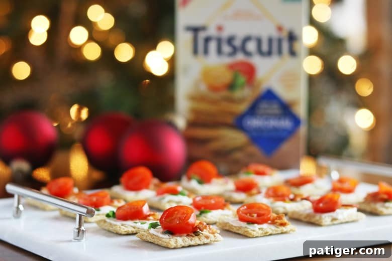 Festive Triscuit Bites 2 Triscuit crackers topped with creamy cheese, crispy bacon, and fresh tomato for a quick and easy holiday appetizer.