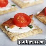 Festive Triscuit Bites 8 Triscuit crackers with cream cheese, bacon, and tomato on a platter