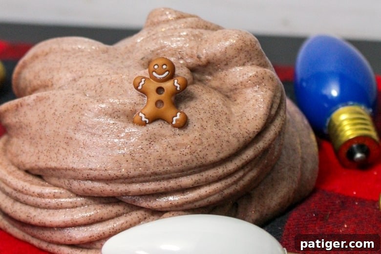 Spiced Gingerbread Slime 2 Gingerbread slime with small gingerbread man toy and Christmas decorations, showcasing its festive appeal and rich brown color.