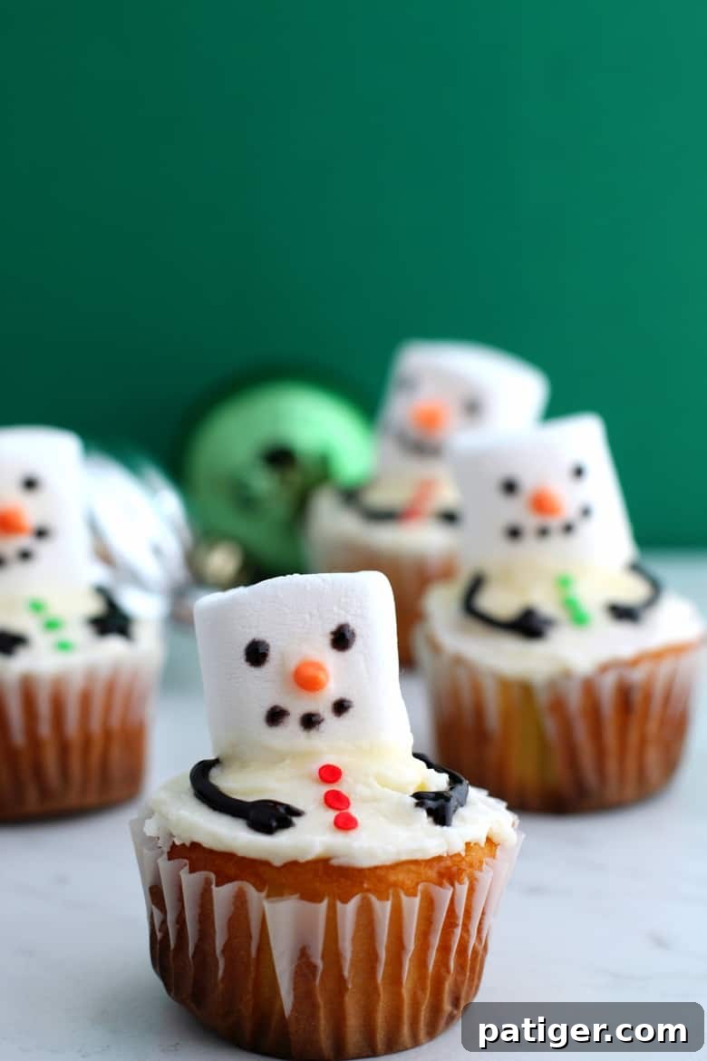 Melting snowman cupcakes are an easy to make Winter dessert made by adding a marshmallow and a few other small decorations to vanilla cupcakes.