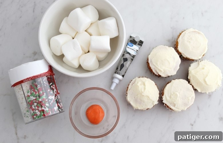 Melting Snowman Cupcakes Ingredients: iced cupcakes, orange fondant, marshmallows, black decorating gel, and sprinkles