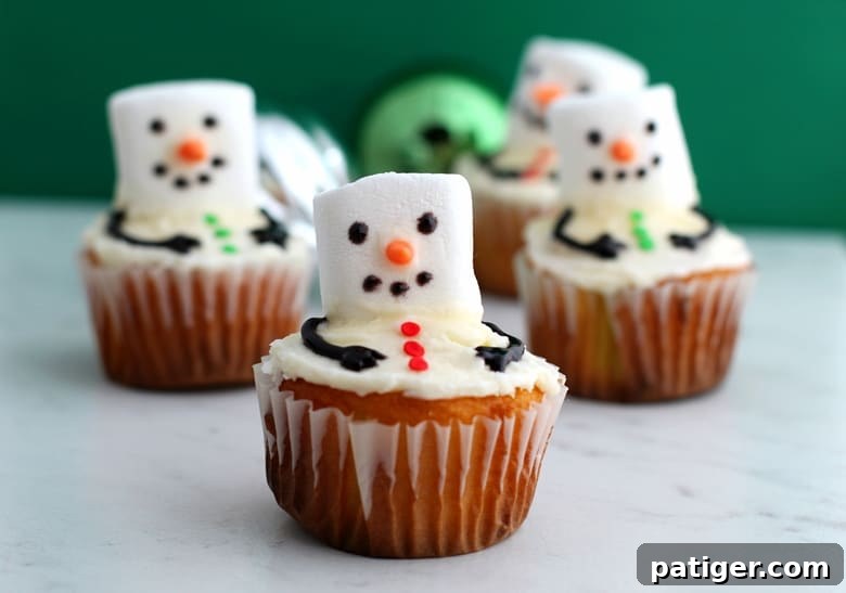 Melting snowman cupcakes are an easy to make Winter dessert made by adding a marshmallow and a few other small decorations to vanilla cupcakes.