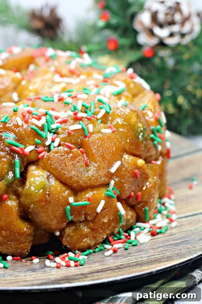 Yuletide Cinnamon Delight 3 Close-up of a Christmas monkey bread ring showcasing its sticky, golden-brown caramelized glaze and vibrant red, green, and white holiday sprinkles.