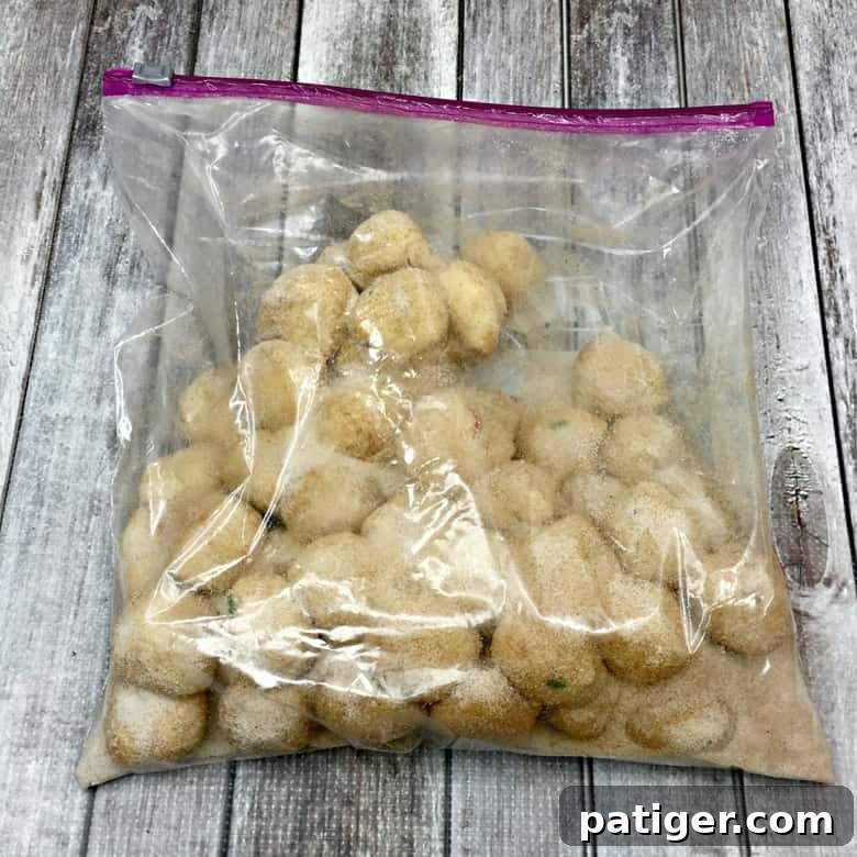 Yuletide Cinnamon Delight 6 A large zipper bag filled with cinnamon sugar mixture, containing several dough balls being tossed to coat them evenly.