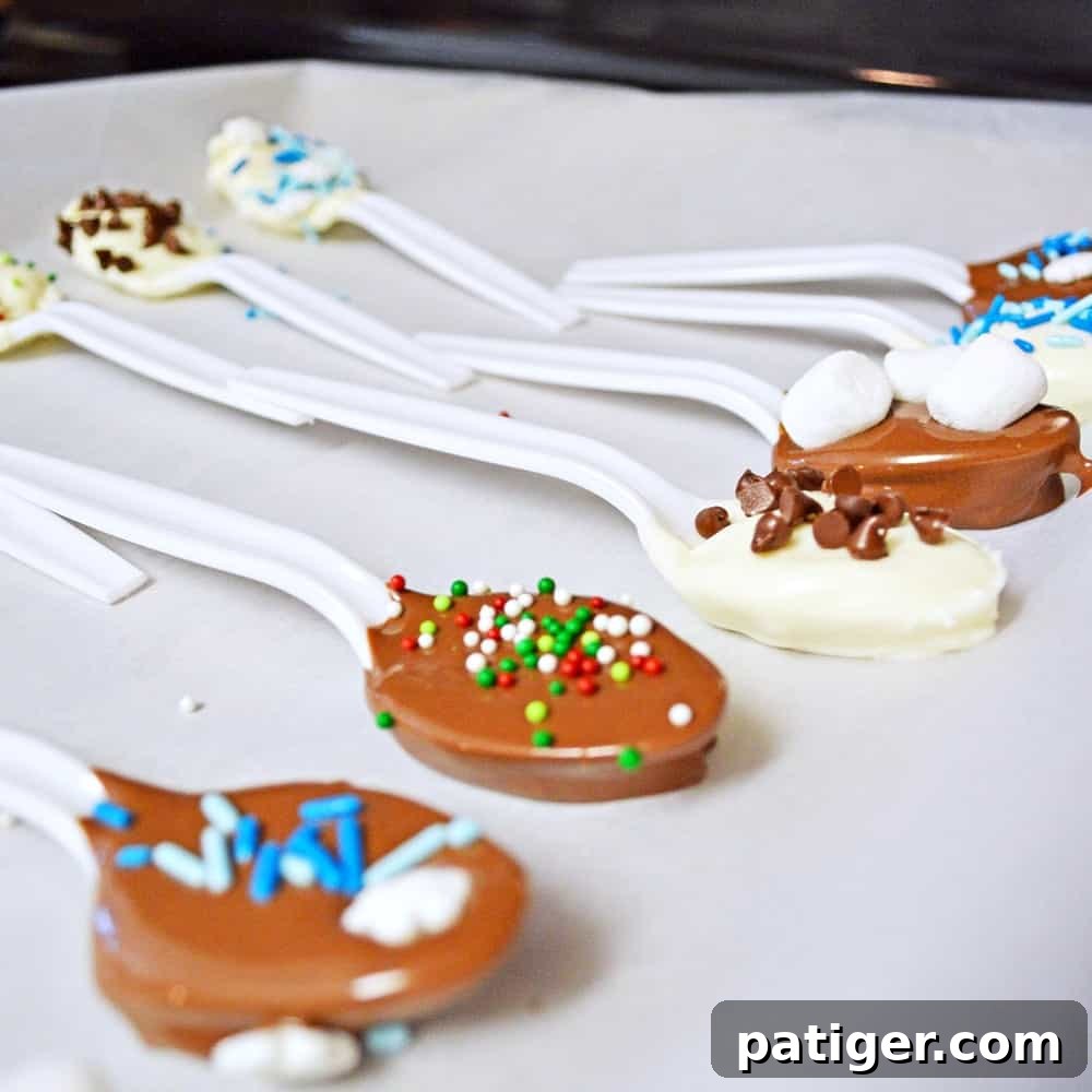 Chocolate dipped spoons setting on a parchment lined baking sheet