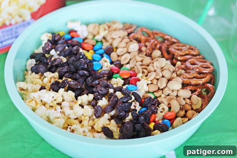 Tailgate Treat: Speedy Sweet and Salty Mix with Custom Football Holders 6 Popcorn, raisins, chocolate candies, and pretzels in a large turquoise bowl