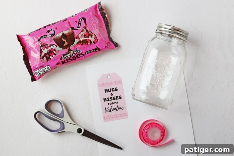 Essential supplies for making a "Hugs & Kisses" mason jar Valentine: jar, Hershey Kisses, cardstock, scissors, ribbon.