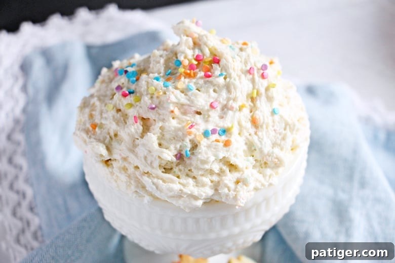 Funfetti dip in a pristine white serving bowl, adorned with an extra scattering of colorful sprinkles.