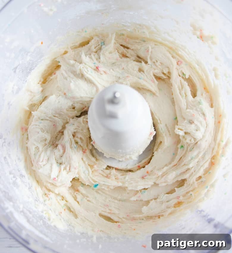The blended cake batter dip ingredients in a food processor, showcasing a perfectly smooth and creamy mixture devoid of any lumps.
