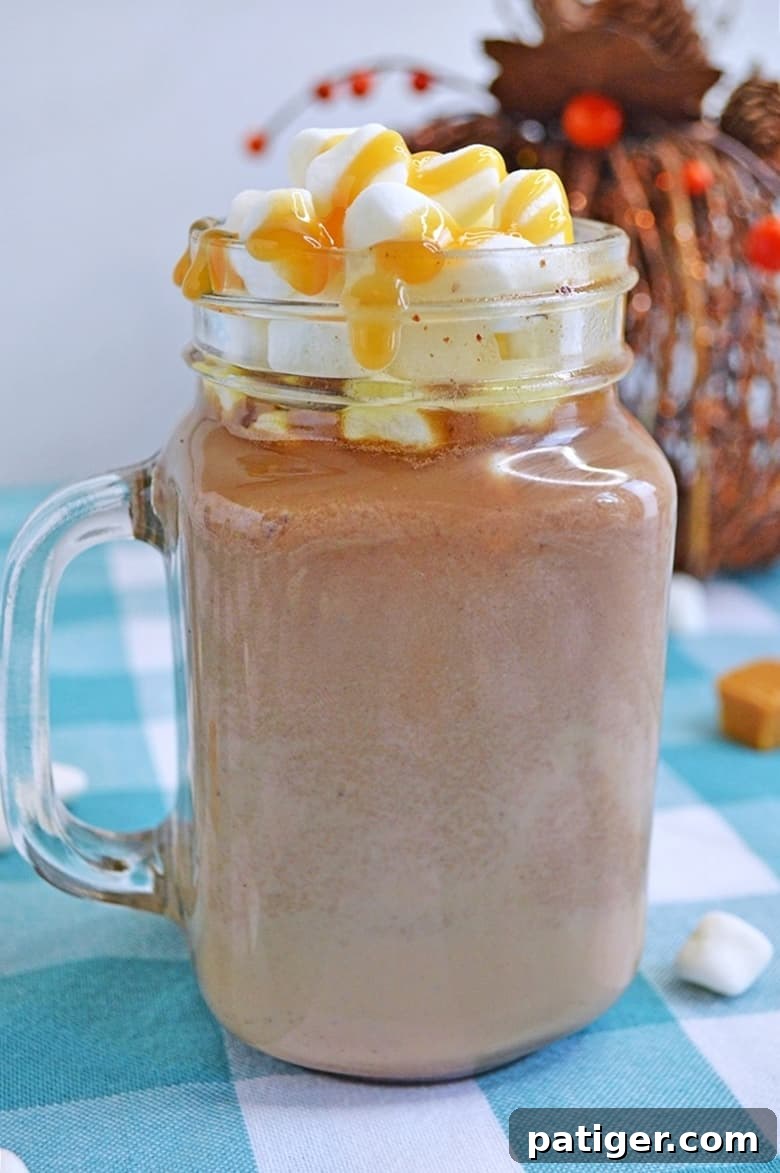 A rich and creamy slow cooker salted caramel hot chocolate recipe that will warm up your bones on those chilly Winter nights. A mug of hot chocolate with whipped cream and caramel drizzle.