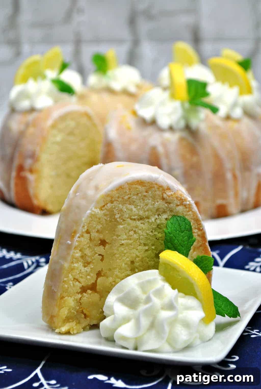 Zesty Lemon Bundt Bliss 3 A close-up of a slice of the moist lemon bundt cake, showing its tender crumb and the glistening lemon glaze on top. Fresh blueberries are scattered around the base, highlighting the vibrant flavors.