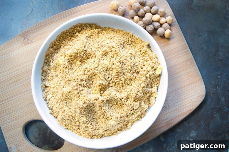 Close-up shot of crushed Reese's Puffs cereal in a white ceramic bowl, resting on a rustic wooden cutting board, ready for incorporation into a delicious waffle batter.
