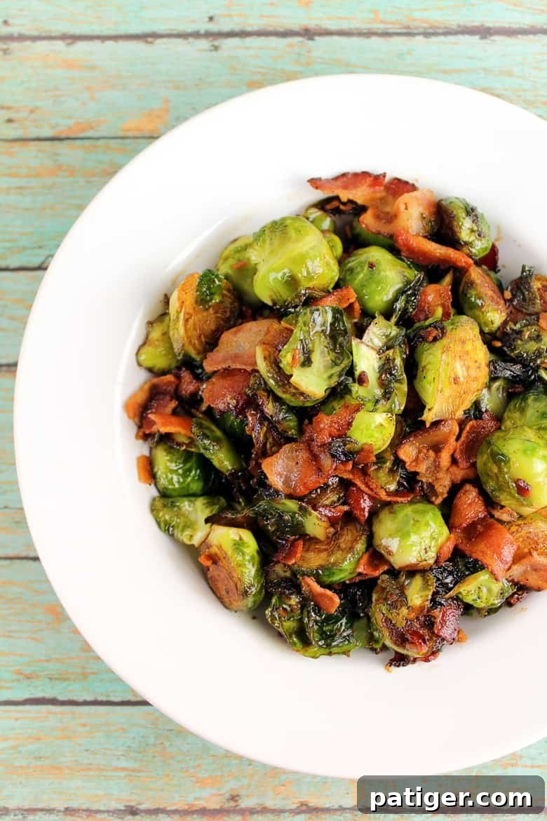 Bacon-Kissed Balsamic Brussels Sprouts 2 Crispy Brussels sprouts with bacon bits and a glossy balsamic glaze, served in a rustic bowl on a wooden surface.