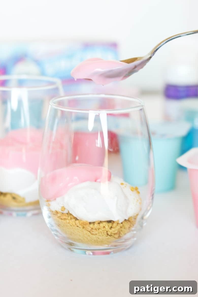Magical Unicorn Swirl Parfaits 8 Spooning pink pudding into parfait glass.