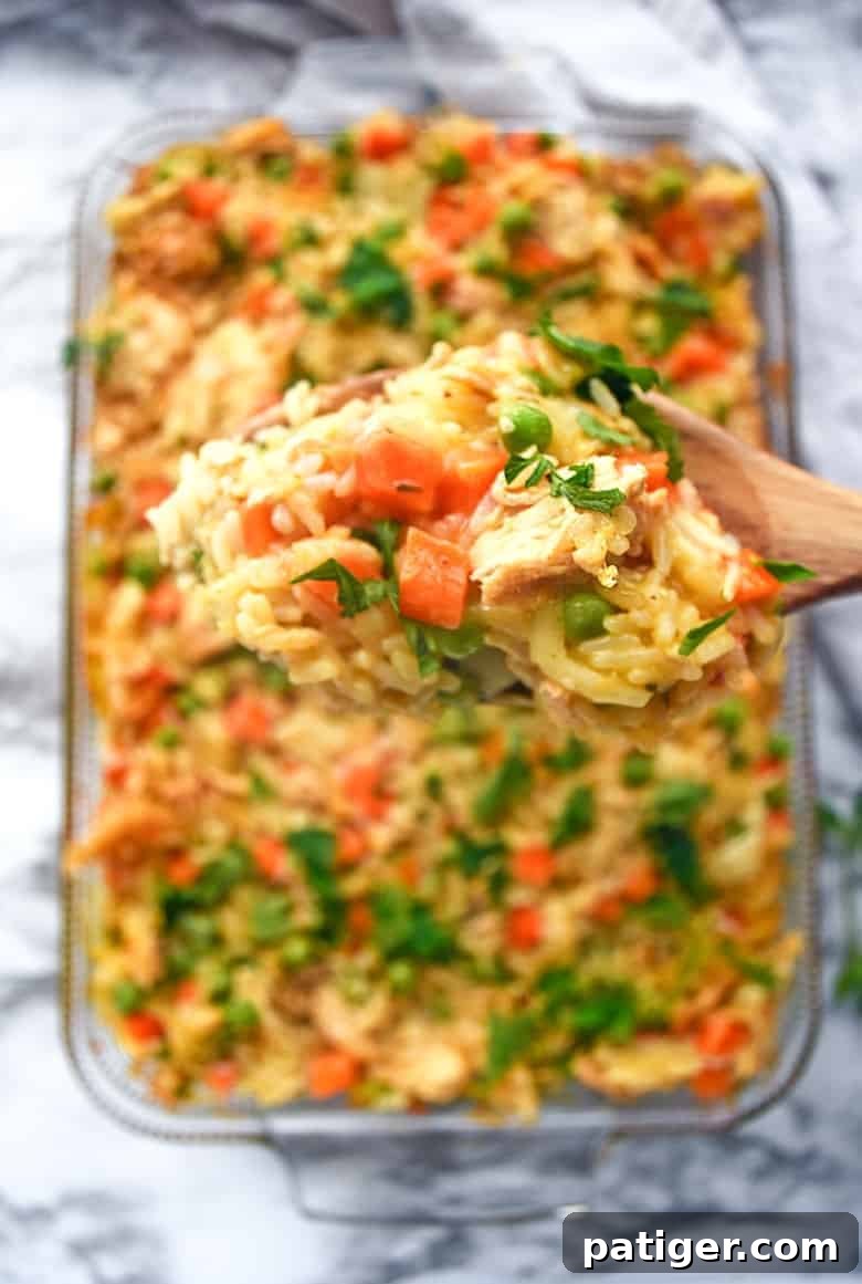 An incredible creamy chicken and rice casserole recipe made with frozen peas and carrots and cream of chicken soup.