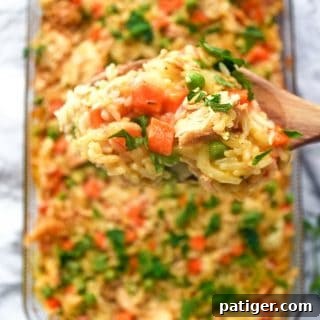 An incredible creamy chicken and rice casserole recipe made with frozen peas and carrots and cream of chicken soup.