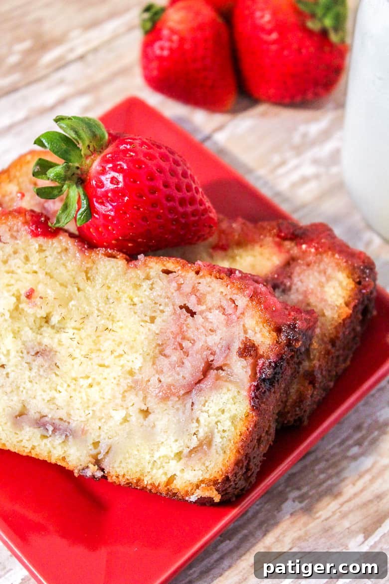 Easy homemade strawberry yogurt cake with a sweet strawberry glaze and fresh strawberry slices.