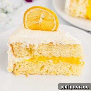 Slice of lemon layer cake with lemon curd filling and marshmallow frosting.