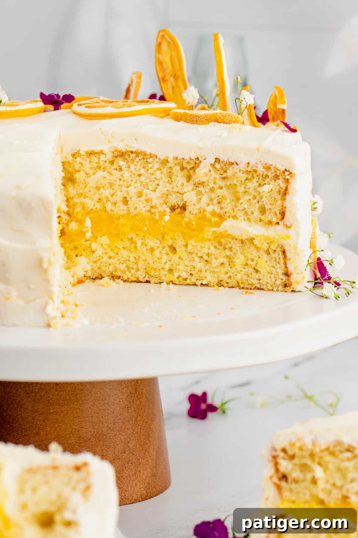 Lemon cake on cake stand with slice removed to show lemon curd filling.