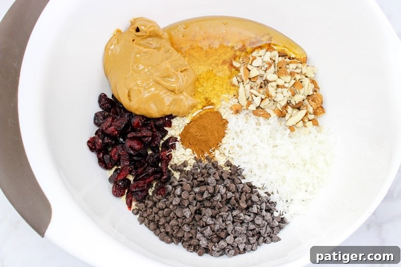 All the ingredients for energy balls combined in a large mixing bowl, ready to be stirred.